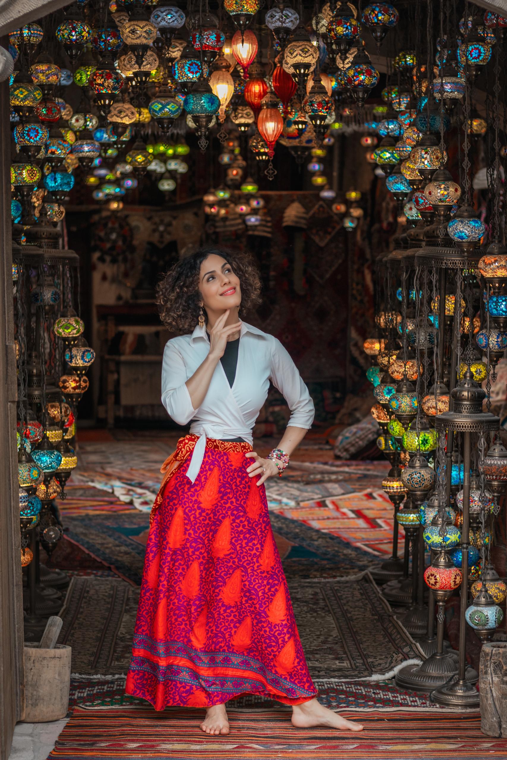 Kati Jalali looking up, surrounded by colorful lanterns, symbolizing leadership transitions.