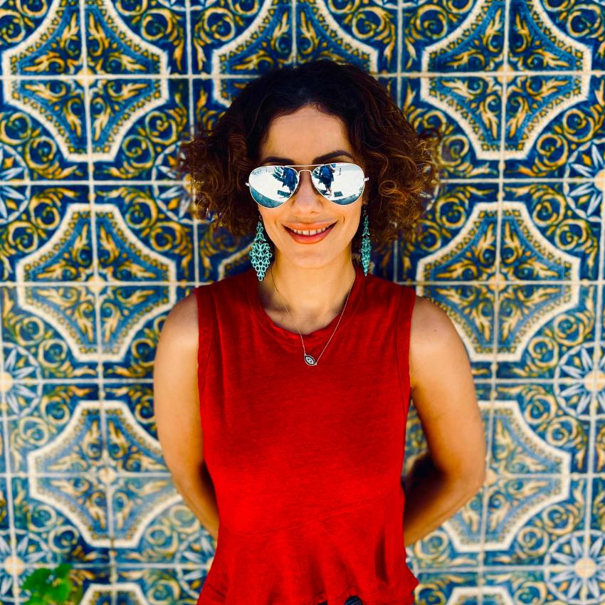 Kati Jalali in front of a wall of colorful tiles focusing on professional skills development.