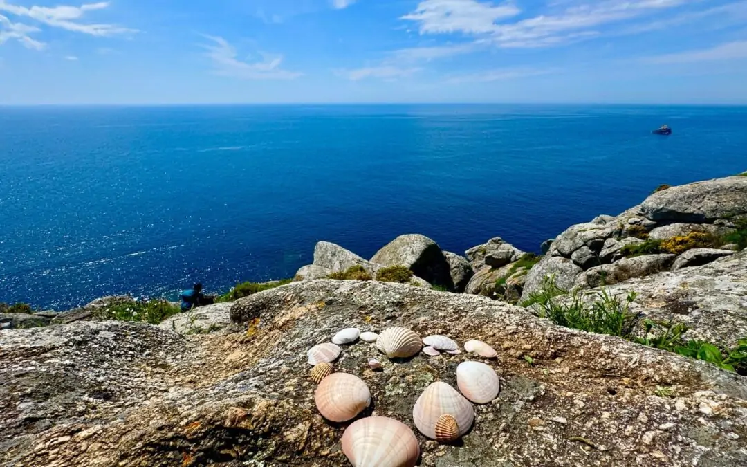 Ocean view with seashells at Finisterre, the symbolic end of the Camino de Santiago—marking reflection, renewal, and personal growth.